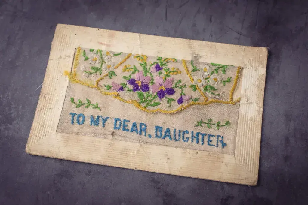 Vintage embroidery on lace war postcard reading to my dear, daughter.